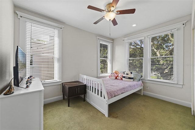 bedroom featuring multiple windows, light colored carpet, and baseboards