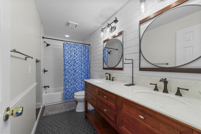 full bath featuring toilet, double vanity, shower / bath combo with shower curtain, and a sink