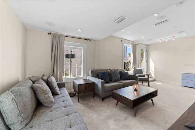 living room featuring light carpet, a healthy amount of sunlight, and visible vents