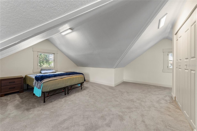 bedroom featuring a textured ceiling, vaulted ceiling, carpet flooring, and baseboards