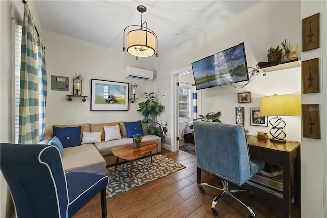 office space with hardwood / wood-style flooring, a textured ceiling, and an AC wall unit