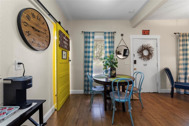 dining area with a barn door, dark wood-style flooring, beam ceiling, and baseboards