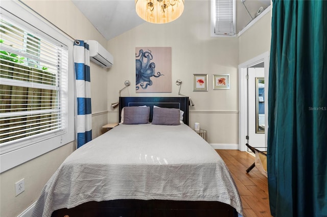 bedroom with baseboards, vaulted ceiling, wood finished floors, and a wall mounted air conditioner