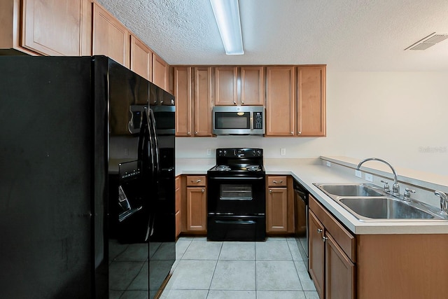 kitchen featuring light tile patterned floors, a sink, black appliances, light countertops, and a textured ceiling