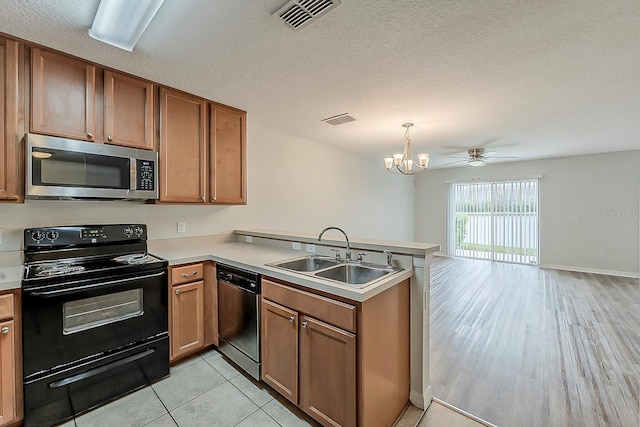 kitchen with black / electric stove, visible vents, a sink, dishwasher, and stainless steel microwave