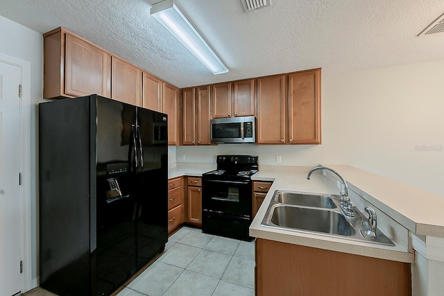 kitchen featuring visible vents, black appliances, a sink, light countertops, and light tile patterned floors