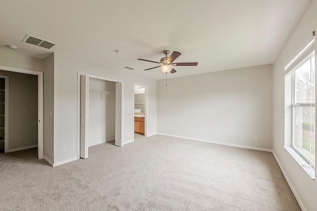 unfurnished bedroom with visible vents, baseboards, light colored carpet, and a closet