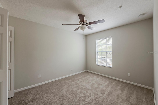 empty room featuring carpet flooring, a textured ceiling, baseboards, and a ceiling fan