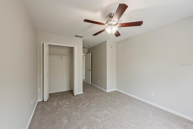 unfurnished bedroom featuring a closet, visible vents, light carpet, and baseboards