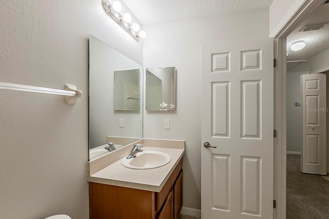 bathroom featuring visible vents, a textured ceiling, and vanity