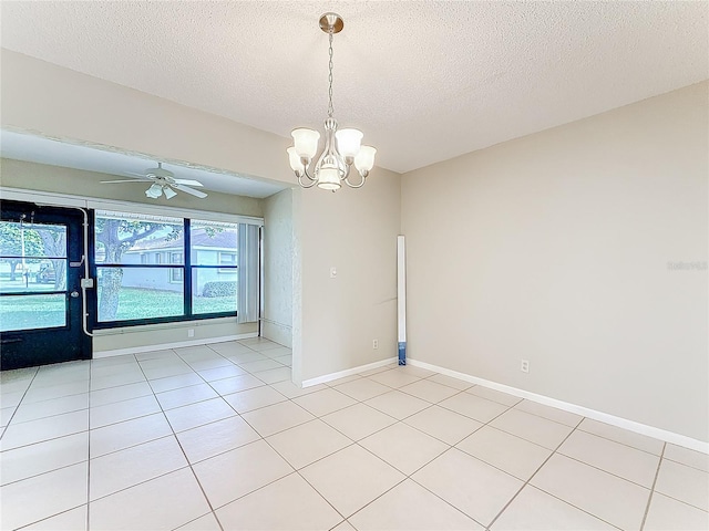 spare room with a textured ceiling, baseboards, and light tile patterned floors