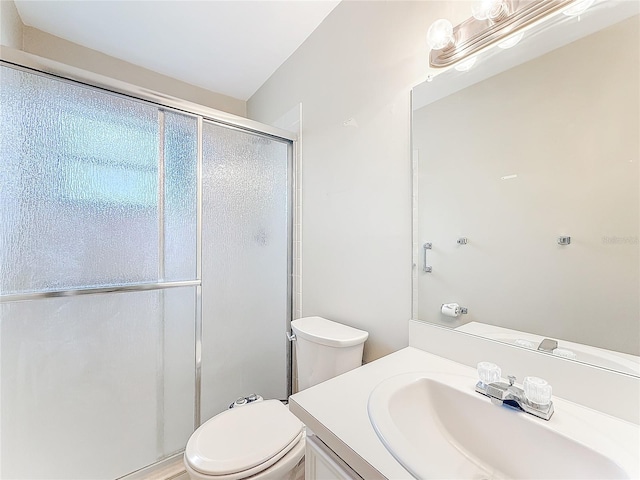 full bath featuring a stall shower, vanity, and toilet