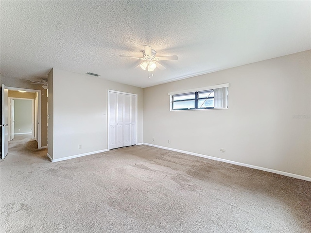 unfurnished bedroom featuring carpet, baseboards, visible vents, and a closet