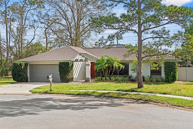 view of front facade featuring driveway, a garage, a front lawn, and stucco siding