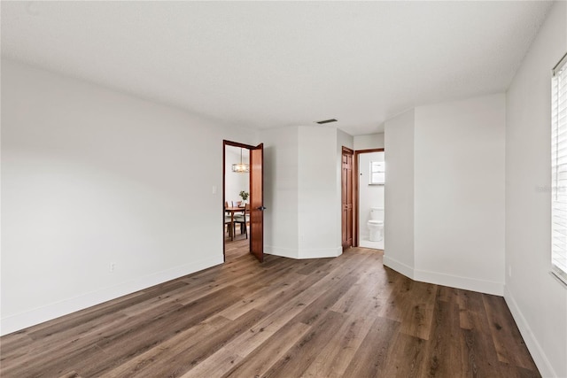 spare room with visible vents, baseboards, and wood finished floors