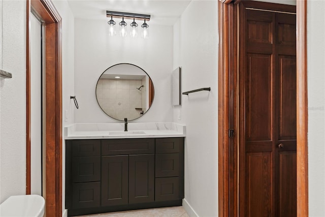 bathroom with baseboards, vanity, and toilet