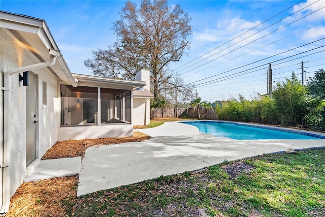 view of swimming pool with a fenced in pool, a sunroom, a fenced backyard, and a patio