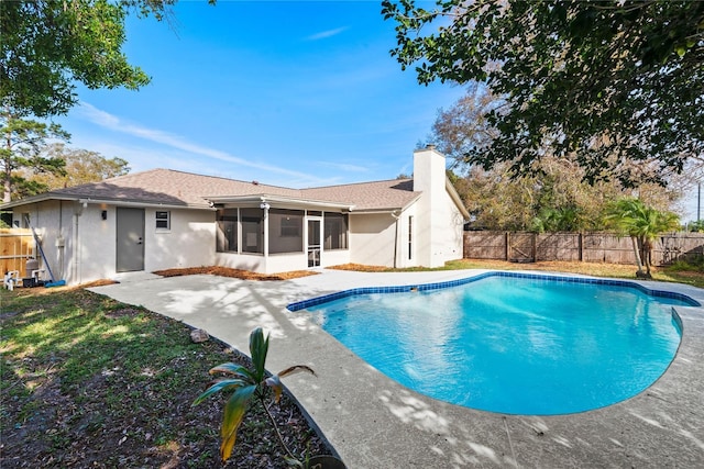 view of swimming pool with a fenced in pool, a sunroom, a patio area, and a fenced backyard