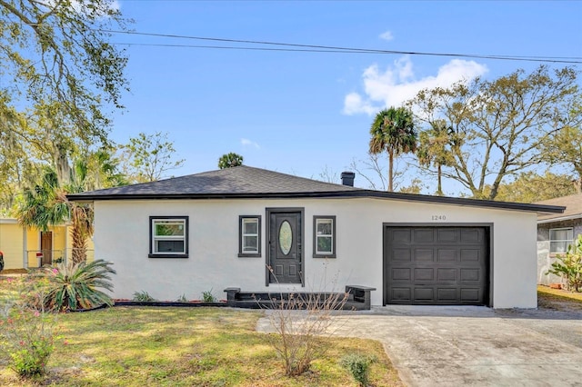 ranch-style home with a garage, a shingled roof, driveway, stucco siding, and a front yard