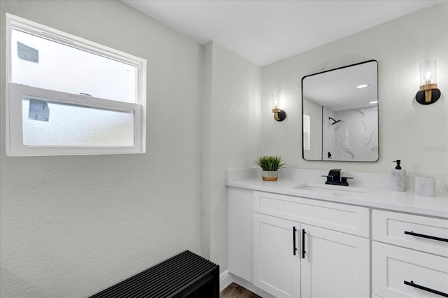 bathroom with walk in shower and vanity