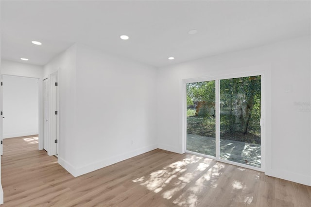 empty room with recessed lighting, wood finished floors, and baseboards