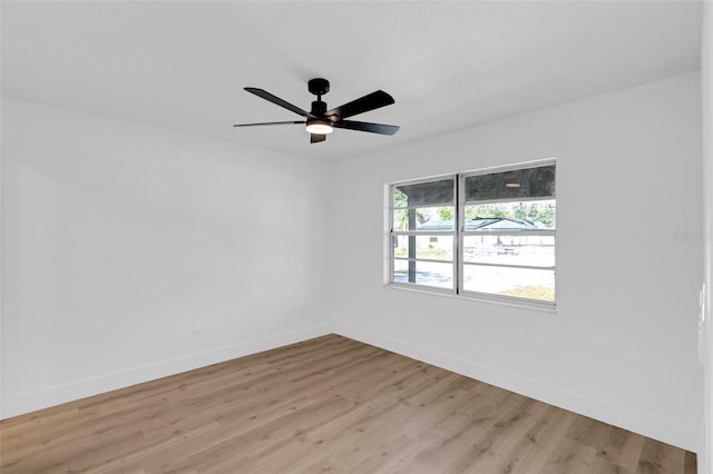 unfurnished room featuring ceiling fan, light wood-style flooring, and baseboards