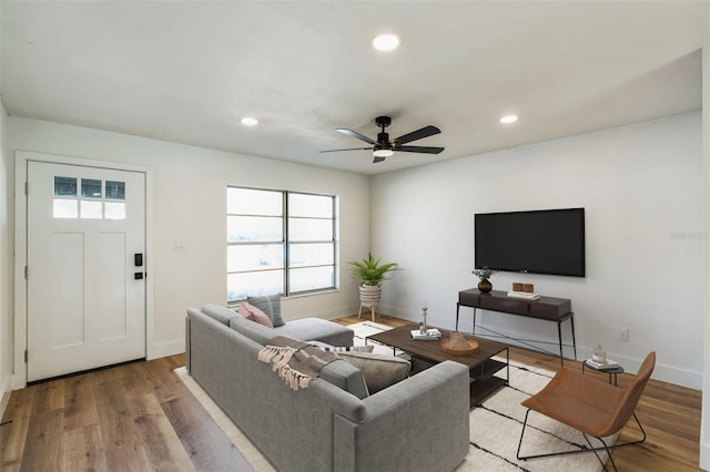 living area featuring baseboards, wood finished floors, a ceiling fan, and recessed lighting