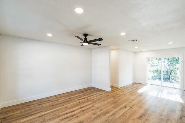 empty room featuring light wood-style floors, recessed lighting, visible vents, and baseboards