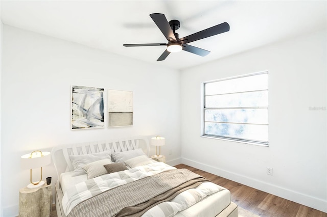 bedroom with a ceiling fan, baseboards, and wood finished floors