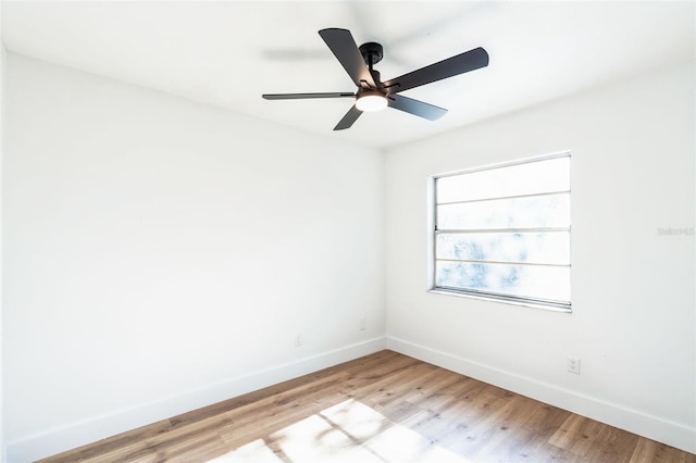 empty room with baseboards, ceiling fan, and light wood finished floors