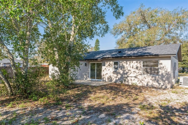 rear view of house with a patio area, fence, and cooling unit