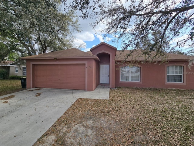 ranch-style home with an attached garage, driveway, and stucco siding