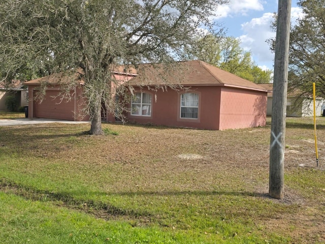 view of front of house featuring a garage, driveway, concrete block siding, and a front lawn