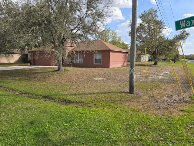 view of home's exterior with an attached garage, driveway, and a yard