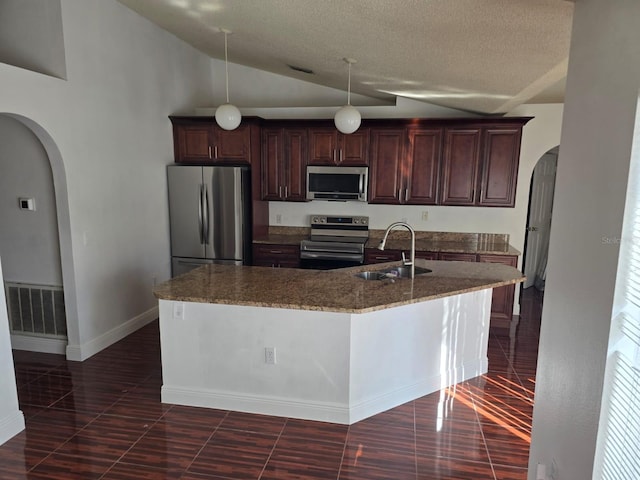 kitchen with visible vents, arched walkways, stainless steel appliances, and a sink