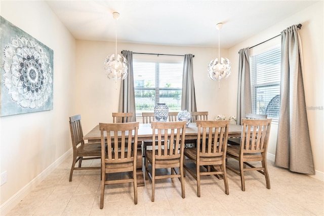 dining room with a healthy amount of sunlight, baseboards, a notable chandelier, and light tile patterned flooring