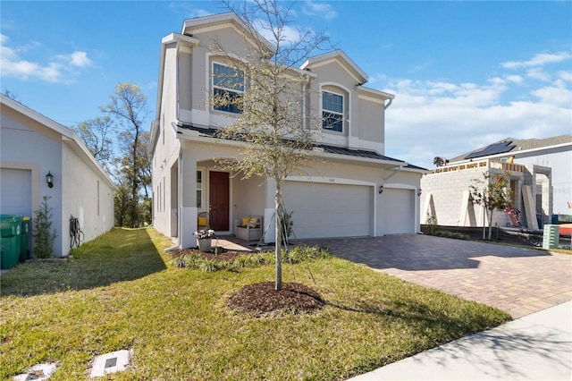 view of front facade with metal roof, an attached garage, a standing seam roof, decorative driveway, and stucco siding