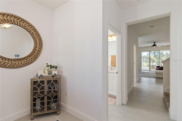 hall with baseboards and light tile patterned flooring