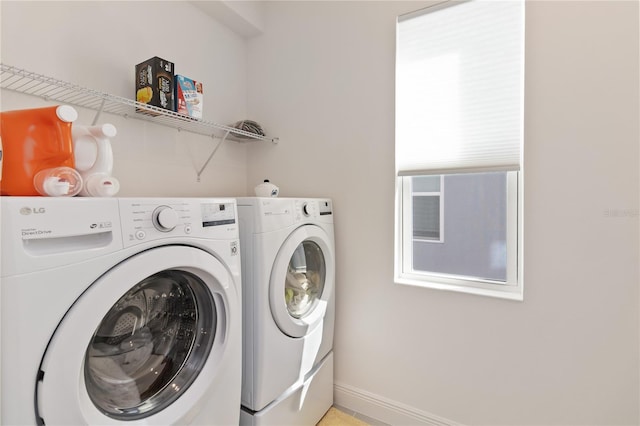 washroom featuring laundry area, washer and clothes dryer, and baseboards