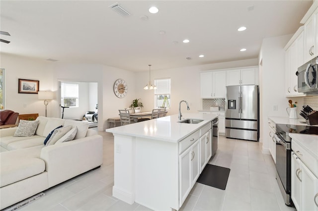 kitchen featuring open floor plan, light countertops, appliances with stainless steel finishes, and a sink