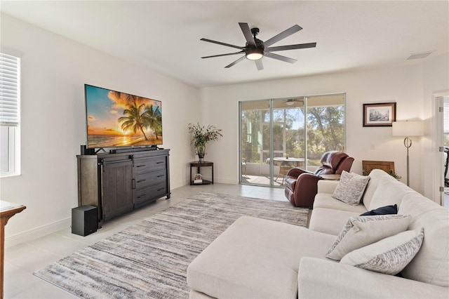 living room with visible vents, light tile patterned flooring, a ceiling fan, and baseboards