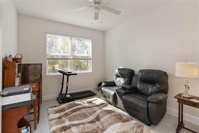 sitting room with ceiling fan, baseboards, and light tile patterned floors