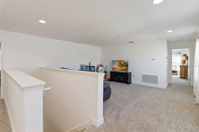 hallway featuring carpet, an upstairs landing, visible vents, and recessed lighting