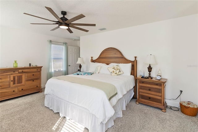 bedroom with visible vents, ceiling fan, light carpet, and a textured ceiling