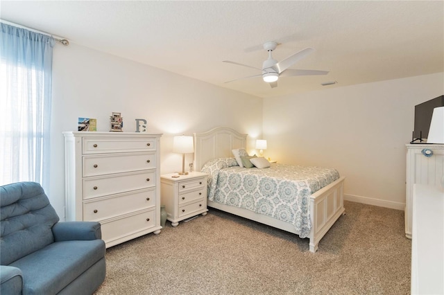 bedroom with baseboards, visible vents, a ceiling fan, and light colored carpet