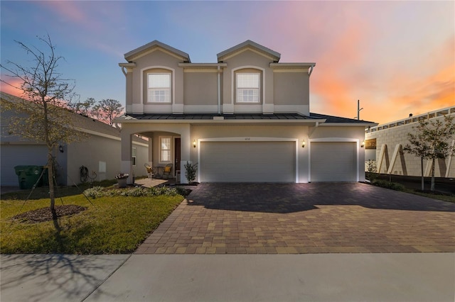 view of front of property with a standing seam roof, metal roof, and decorative driveway