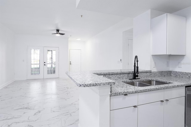 kitchen featuring a sink, white cabinetry, marble finish floor, french doors, and light stone countertops