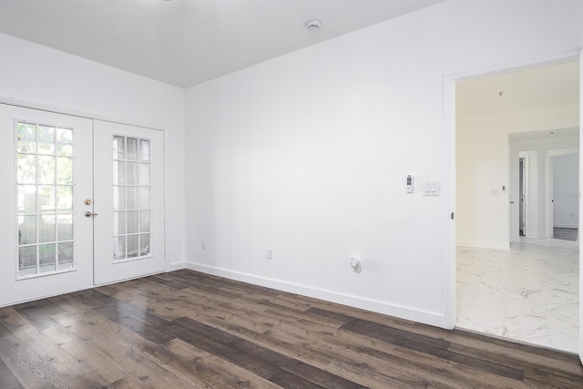 empty room with french doors, baseboards, and wood finished floors