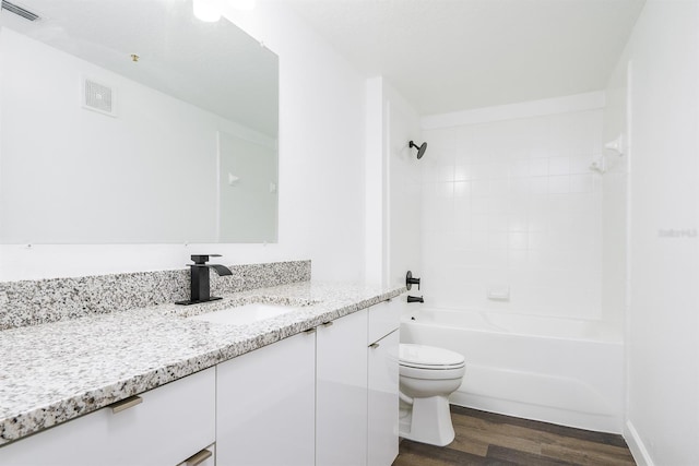 full bath with toilet, visible vents, wood finished floors, and vanity