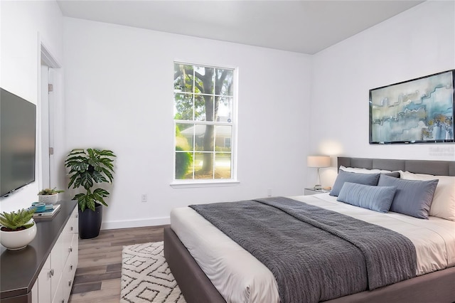 bedroom featuring light wood-style flooring and baseboards